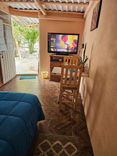 a room with a tv and a chair and a bed at Casa Amarilla Tecámac in Santa Cruz Tecamac