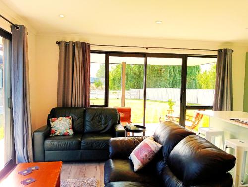 a living room with a leather couch and a table at Cozy Cottage on Begg Lane in Cromwell