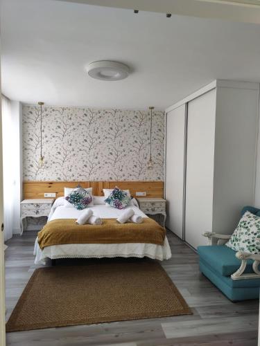 1 dormitorio con 1 cama grande y 1 sofá azul en APARTEMENTO EN LA RIBERA, en Córdoba