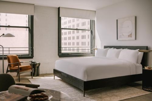 a bedroom with a large white bed and two windows at Sonder The Winfield in Los Angeles