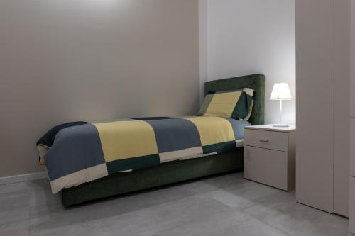 um quarto com uma cama e uma mesa de cabeceira com um candeeiro em La casa sul Naviglio em Milão