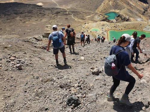 a group of people walking on a rocky mountain at Tongariro Crossing Lodge in National Park