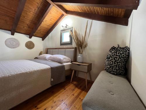 a bedroom with two beds and a bench in it at Villa Filira in Achladies