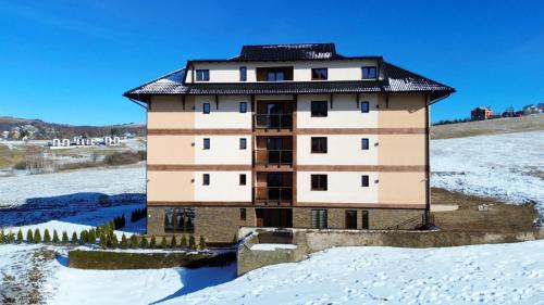 a building in the middle of a snow covered field at Vila Eden Lux in Zlatibor