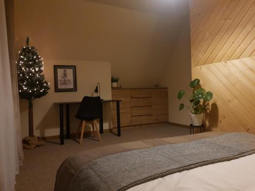a bedroom with a christmas tree and a desk at Biały Domek Rafaczówki in Suche