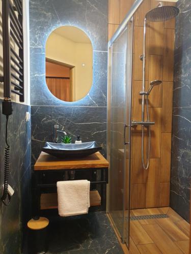 a bathroom with a sink and a mirror at Biały Domek Rafaczówki in Suche