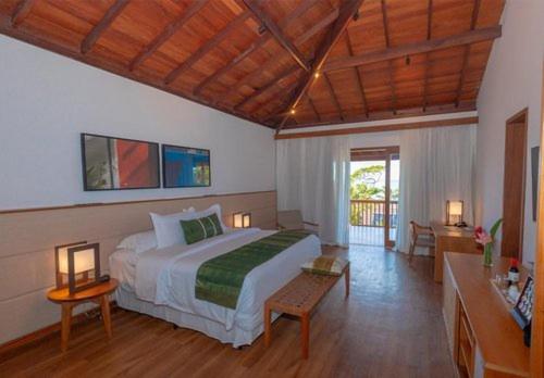 a bedroom with a large bed in a room at Kûara Hotel in Arraial d'Ajuda