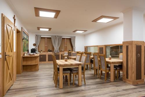 uma sala de jantar com mesas e cadeiras de madeira em Apartament Nad Stajnią em Krośnica