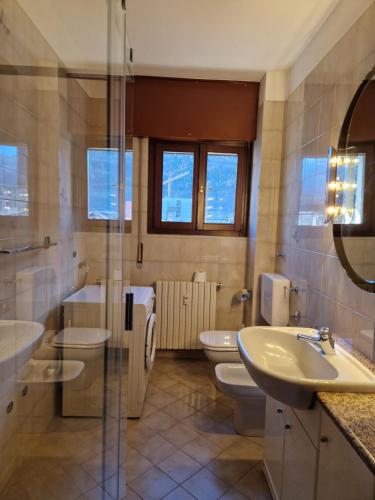 a bathroom with two toilets and a sink and a shower at La casa di Giò in Tirano