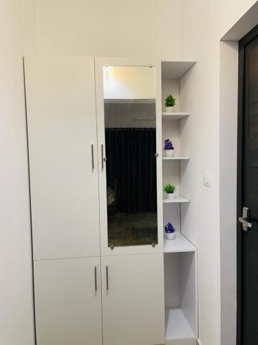 a white cabinet with a mirror in a room at SALT LIFE MARARI BEACH VILLA in Mararikulam