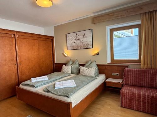 1 dormitorio pequeño con 1 cama y 1 silla en MB Apartment en Ramsau im Zillertal