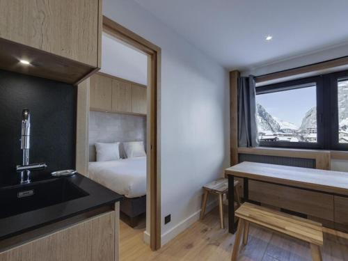 une chambre avec un lit, un lavabo et une fenêtre dans l'établissement Charmant 3 Pièces avec Parking, Wifi, et Proche Remontées à Val d'Isère - FR-1-567-90, à Val dʼIsère