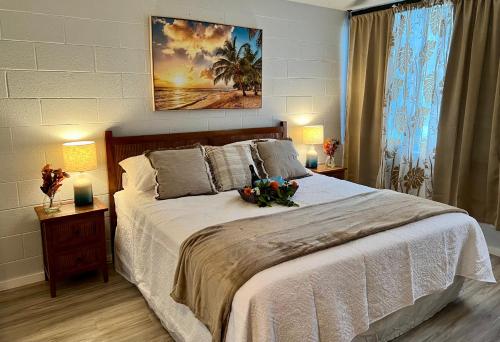 um quarto com uma grande cama branca e 2 candeeiros em Ocean view Mauna Loa Shores Kai Ekahi #201 next to Carlsmith Beach Park Hilo HI em Hilo