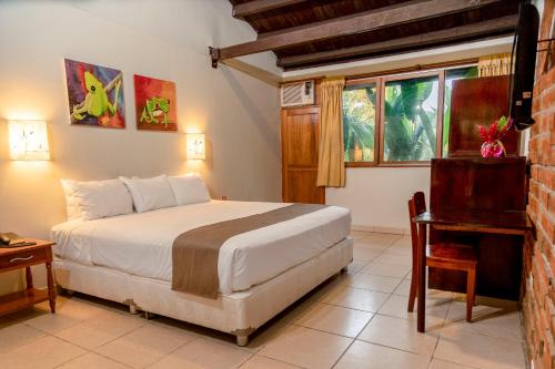 um quarto com uma cama, uma secretária e uma janela em DM Hoteles Tarapoto em Tarapoto