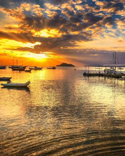 a group of boats on the water at sunset at Pousada L'étage in Búzios