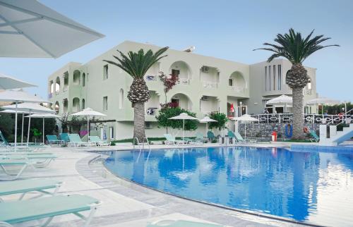 einen Pool im Resort mit Palmen und Stühlen in der Unterkunft Vardis Olive Garden in Georgioupoli