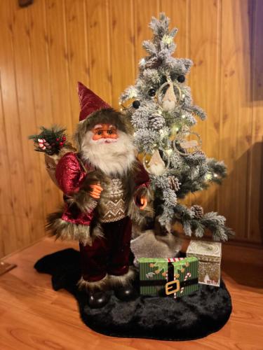 a santa claus statue next to a christmas tree at Chalet Látky in Látky