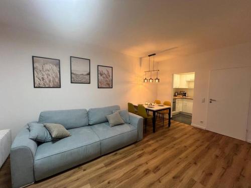 sala de estar con sofá azul y mesa en BRAN: Design - Apartment Küche, Parken ,Netflix, en Bad Rothenfelde