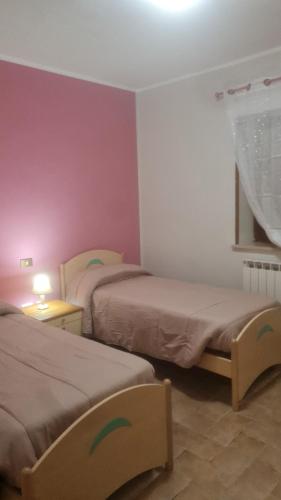 two beds in a room with purple walls at Casa Fiore in Cerreto di Spoleto