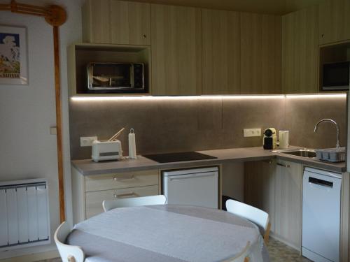 une cuisine avec une table, des chaises et un évier dans l'établissement Appartement lumineux, 6 personnes avec balcon, parking, WiFi à 900m du centre de Châtel - FR-1-198-233, à Châtel