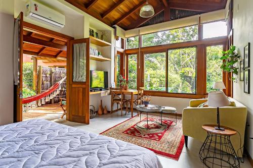 a bedroom with a bed and a living room at Ateliê aconchegante em meio à natureza ATL018 in Florianópolis