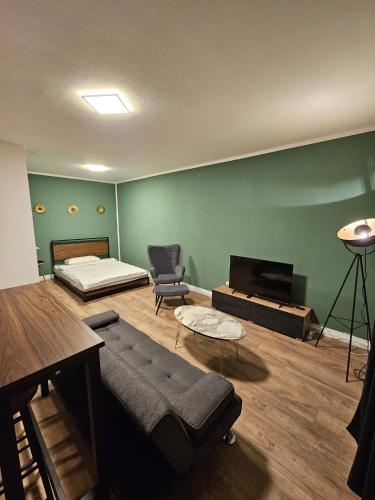 Zimmer mit einem Bett, einem Sofa und einem Stuhl in der Unterkunft Sweet Home - 5 - in Duisburg