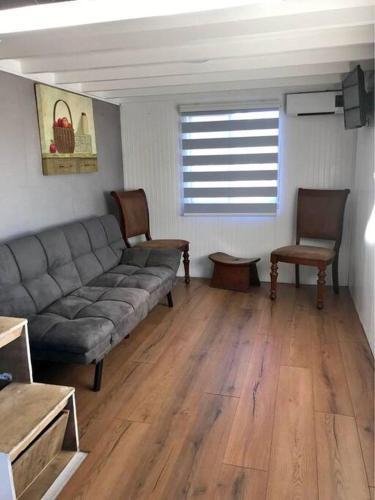 een woonkamer met een bank en 2 stoelen bij Tinny house Cunco, Araucanía in Cunco