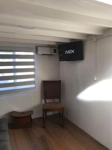 a room with a chair and a sign on the wall at Tinny house Cunco, Araucanía in Cunco