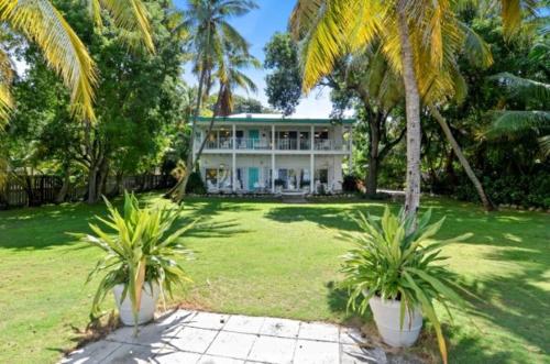 a house with two palm trees in front of it at LIttle Bay Lower in Islamorada