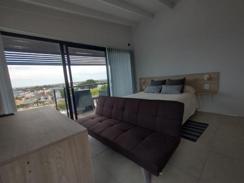 a bedroom with a bed and a couch and a window at Los Miradores del Terrado in Las Grutas