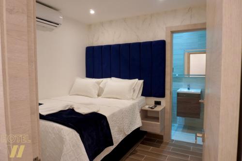 a bedroom with a bed with a blue headboard at HOTEL W Santa Marta in Gaira