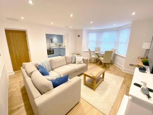 a living room with a white couch and a table at Central Llandudno, Private Parking near to Beach, Pier & Shops in Llandudno