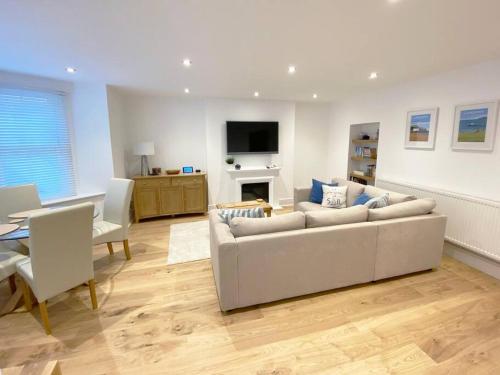 a living room with a white couch and a table at Central Llandudno, Private Parking near to Beach, Pier & Shops in Llandudno