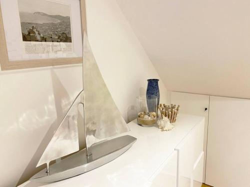 a white room with a staircase with a mirror and vases at Central Llandudno, Private Parking near to Beach, Pier & Shops in Llandudno