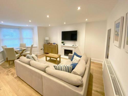 a white living room with a couch and a table at Central Llandudno, Private Parking near to Beach, Pier & Shops in Llandudno