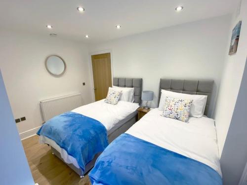 two beds sitting next to each other in a room at Central Llandudno, Private Parking near to Beach, Pier & Shops in Llandudno