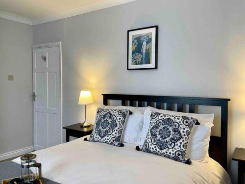 ein Schlafzimmer mit einem Bett mit Kissen und einem Bild an der Wand in der Unterkunft Portsmouth Urban Haven in Portsmouth