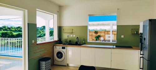 a kitchen with a washer and dryer in a room at Kukumi's House in Sainte-Anne