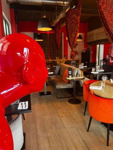 a restaurant with red chairs and tables in a room at Skol l'Original in Luxembourg