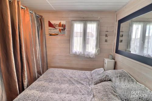 a small bedroom with a bed and a mirror at Villa Tamaris in Gruissan