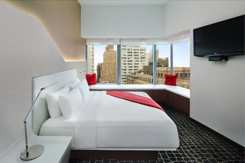 a hotel room with a bed and a large window at The Washington Hotel NYC in New York