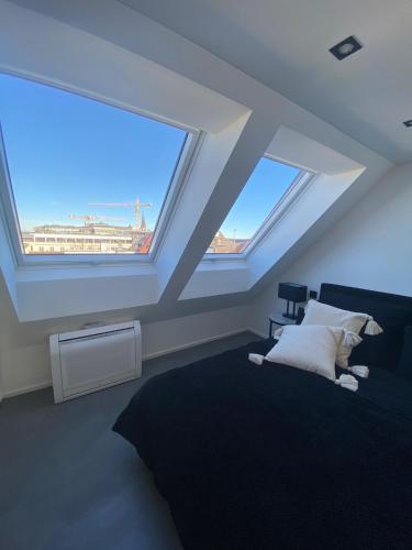 a bedroom with two large windows and a bed at Suite One Löwengrube in Munich