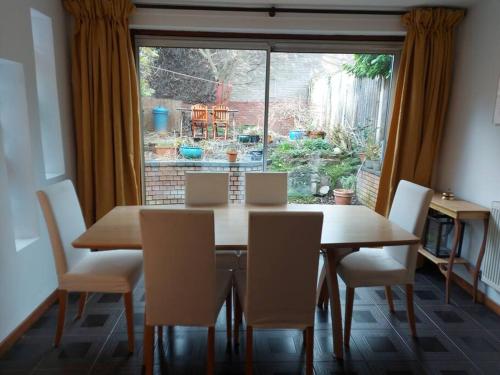 comedor con mesa, sillas y ventana en Spacious 3 bedroom house in lovely location en Birmingham