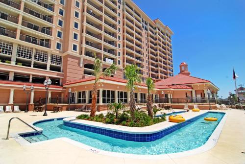 a hotel with a swimming pool in front of a building at Tilghman Beach and Golf Resort in Myrtle Beach