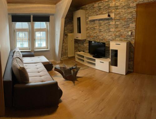 uma sala de estar com um sofá e uma televisão em Moderne Wohnung im Zentrum und Alte Wohnung im Zentrum em Eitorf
