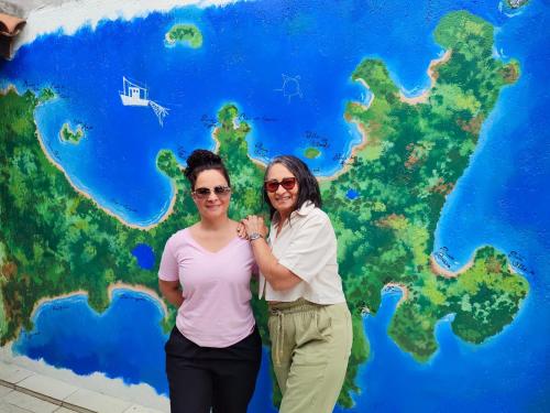 two women standing in front of a world map at Pousada L'étage in Búzios