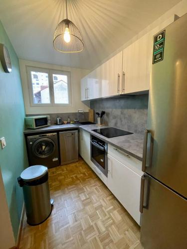 une cuisine avec un réfrigérateur et un lave-vaisselle dans l'établissement Le lotus 71, à Chalon-sur-Saône