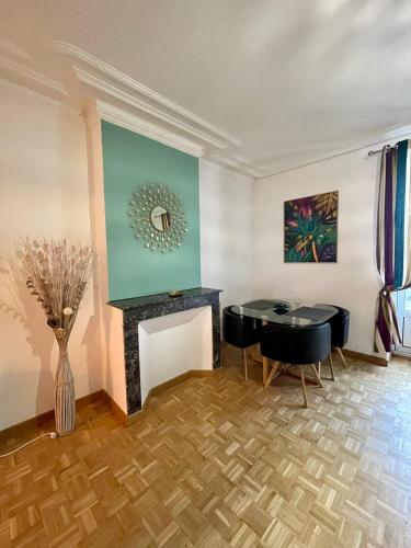 un salon avec une table et une cheminée dans l'établissement Le lotus 71, à Chalon-sur-Saône