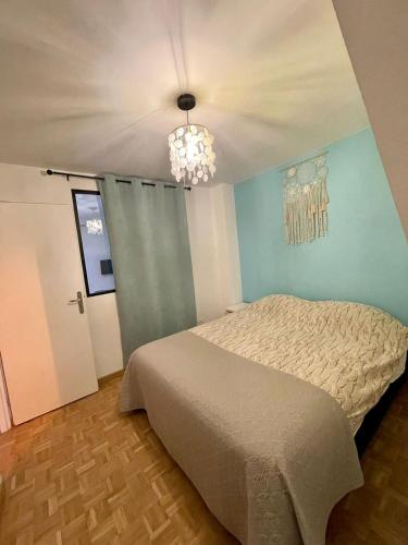 une chambre avec un lit et un lustre dans l'établissement Le lotus 71, à Chalon-sur-Saône