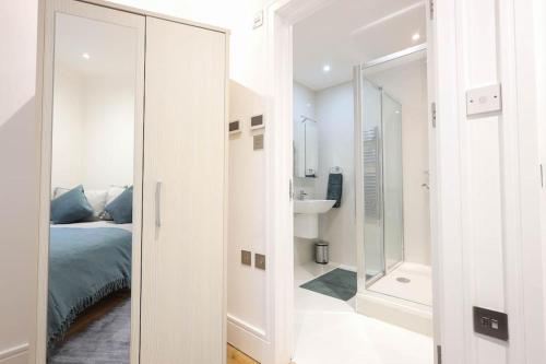 a bedroom with a bed and a bathroom with a mirror at City Centre, Spacious, Ensuite, Smart TV, Sofa Bed in Bristol